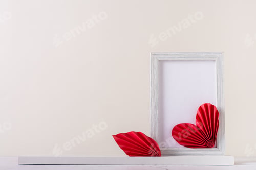 Preview: Blank photo frame decorated with DIY paper hearts. Home decor. Copy space