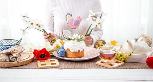 Preview: A woman decorates a festive table with flowers for the celebration of Easter.