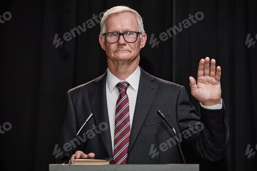 Preview: Male Politician in Suit Raising Hand Taking Oath to Obey Constitution at Podium Indoors