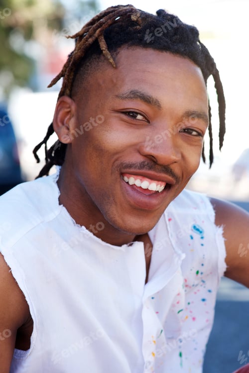 Preview: young black man with dreadlocks smiling outside