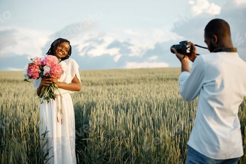 Preview: Happy couple with camera at summer field