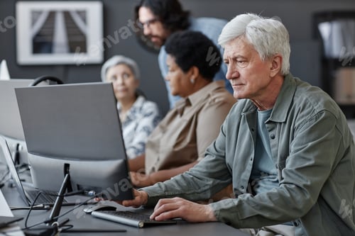 Preview: White haired senior man using computer in tech school for elderly people