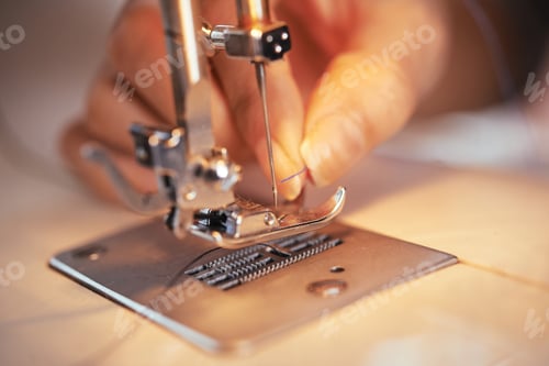 Preview: Crop hand putting thread in needle of sewing machine