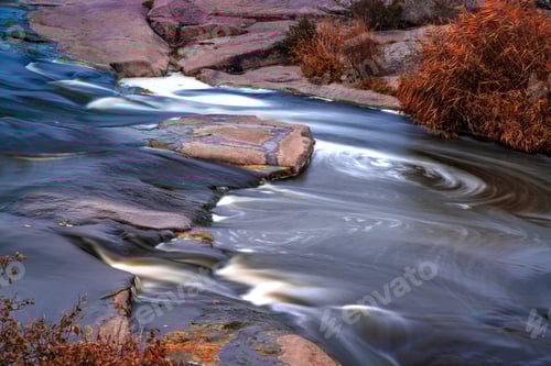 Preview: Stream runs among white wet stones covered with grass in golden autumn