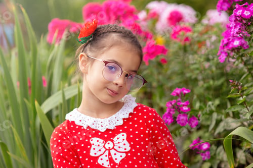 Preview: A portrait of beautiful little girl in glasses in garden