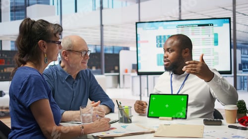 Preview: Expert shows tablet with mockup chroma key to mature couple in office