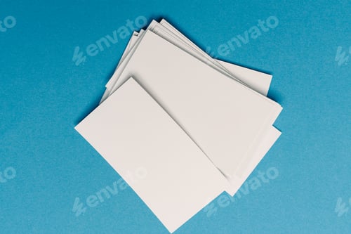 Preview: white business cards in the office on blue glass top view mockup