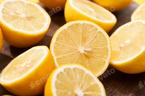 Preview: close up view of ripe cut lemons on wooden cutting board