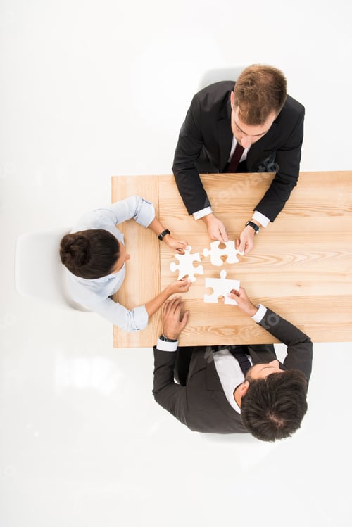 Preview: overhead view business people with puzzles at workplace isolated on white
