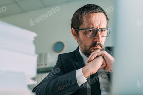 Preview: Distressed businessman looking at laptop screen in business office