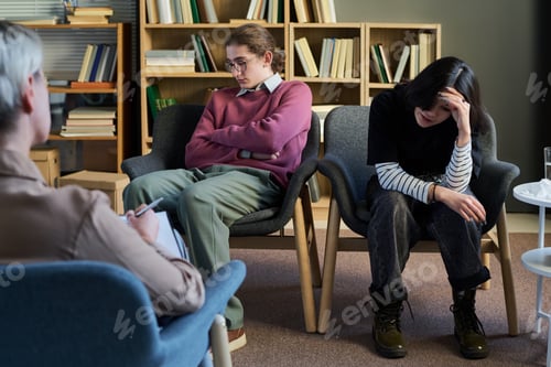 Preview: Two Young Women Participating in Group Therapy Session Indoors