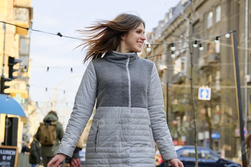 Preview: Young beautiful smiling woman walking along the street of the spring city