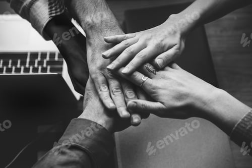 Preview: Team of business people stacking hands