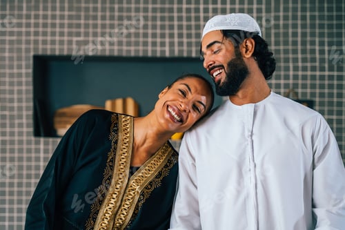 Preview: Happy beautiful young arab couple with emirati clothing together at home