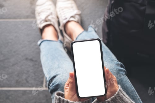 Preview: a woman holding black mobile phone with blank desktop screen with baggage