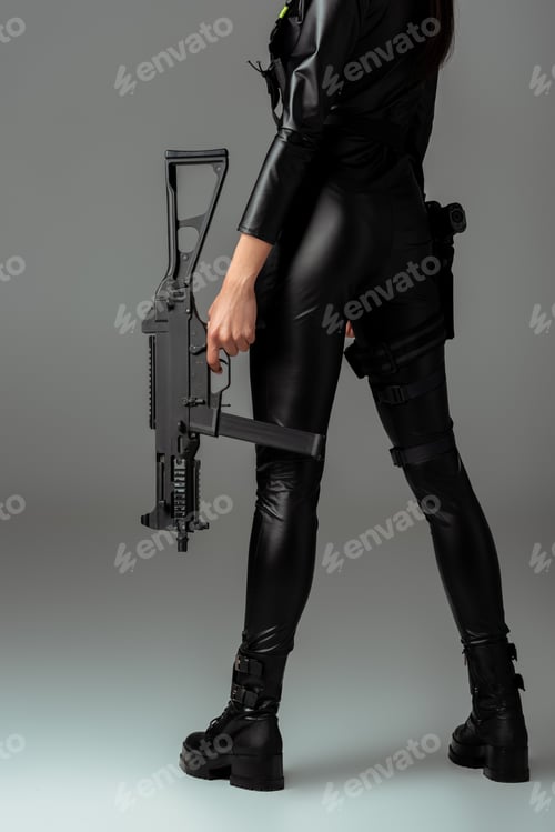 Preview: cropped view of futuristic african american woman posing with assault rifle on grey