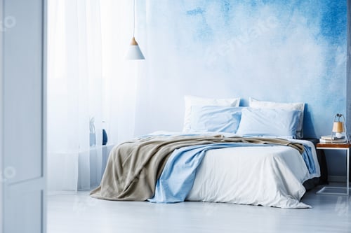 Preview: Yellow and blue bedding on white bed in minimal bedroom interior
