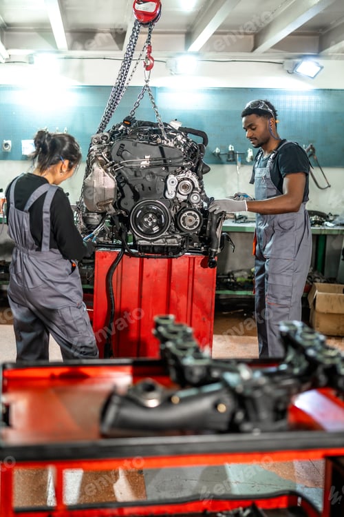 Preview: Mechanics working on car engine in auto repair shop
