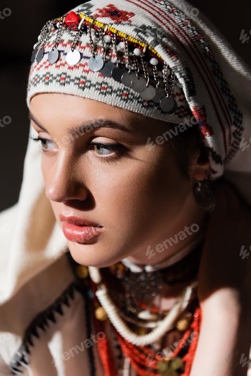 Preview: portrait of young ukrainian woman in traditional headwear with ornament and red beads on black