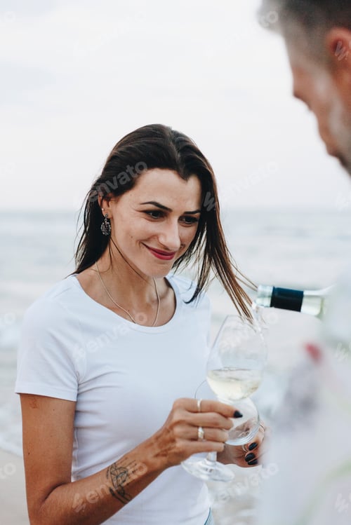Preview: Couple enjoying a glass of wine by the beach