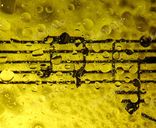 Preview: Music notes on glass flooded with drops with a yellow background
