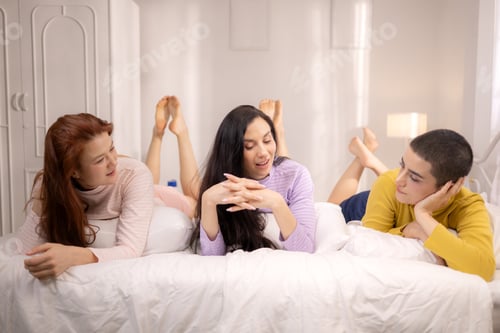 Preview: A group of three women relaxing together on a cozy bed