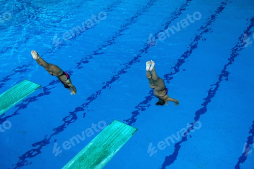 Preview: Female diver jumping from board, demonstrating grace and precision in mid-air.