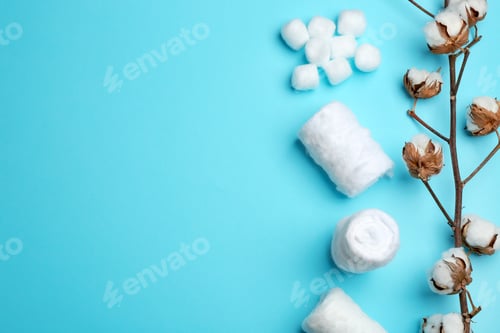 Preview: Flat lay composition with cotton rolls and balls on color background, space for text