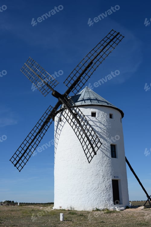 Preview: Towering windmill in vast field under sky in Campo de Criptana, Spain