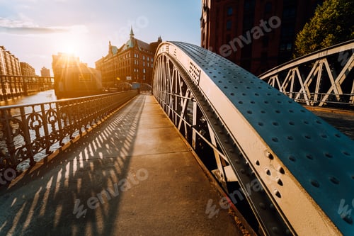 Preview: Metal arch bridge with rivets in the Speicherstadt of Hamburg during sunset golden hour with