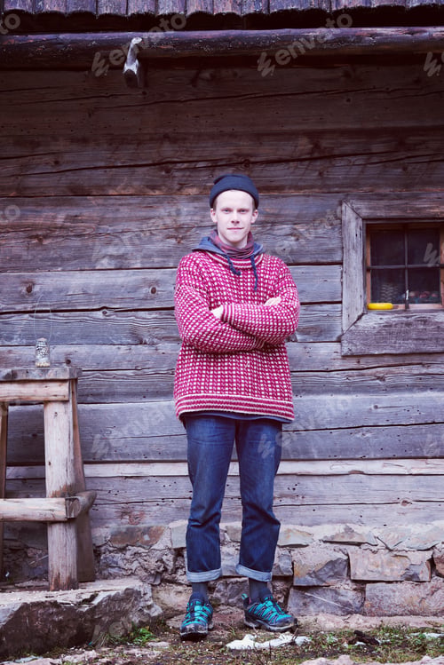 Preview: young hipster in front of wooden house