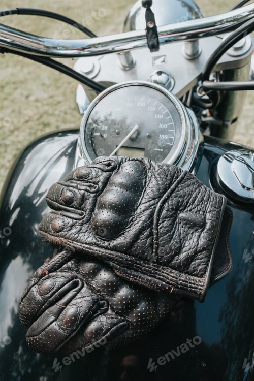 Preview: Close up of a pair of gloves over motorbike. Travel concept. Gloves and rude hands