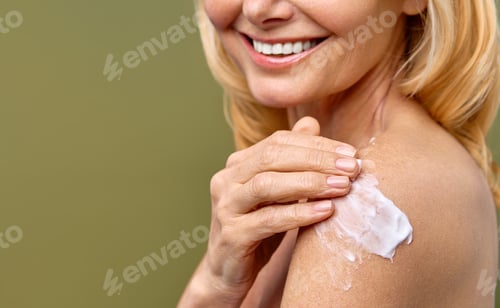 Preview: A woman is smiling as she applies skincare cream on her shoulder