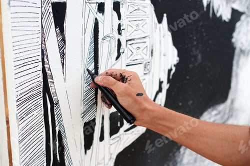 Preview: Young male painter passionately paints picture with black permanent marker for street exhibition