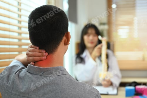 Preview: Male patient touching painful neck near explaining to physiotherapist about his pain.