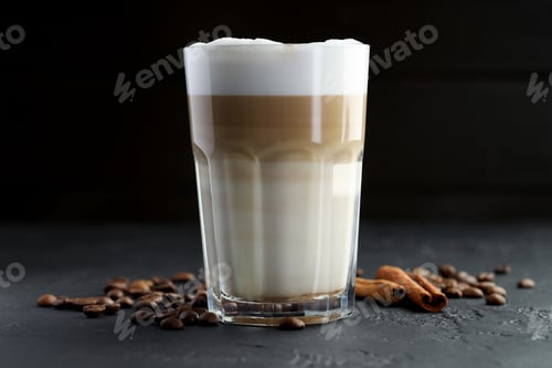 Preview: Tasty latte macchiato in glass, coffee beans and cinnamon on black table, closeup