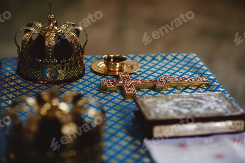 Preview: Orthodox golden wedding crowns, church icons, church books, gospel on the table. selective focus