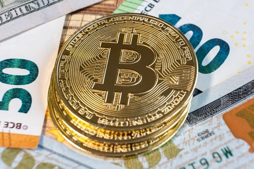 Preview: Close up of metal shiny bitcoin crypto currency coins on US dollar bills. Electronic decentralized