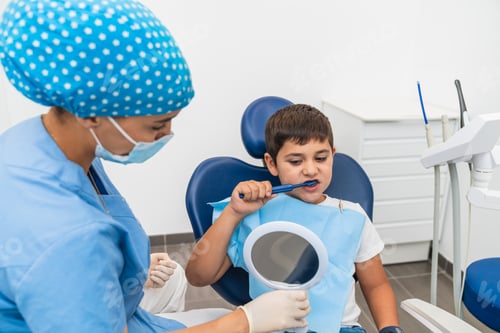 Preview: Child learning to brush teeth properly with help from dental hygienist and a handheld mirror.