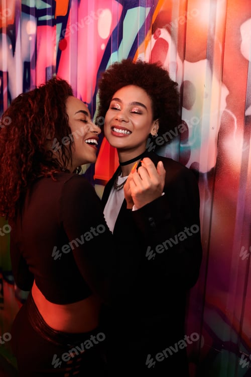 Preview: Joyful moment shared between two friends in a vibrant urban setting during a lively evening