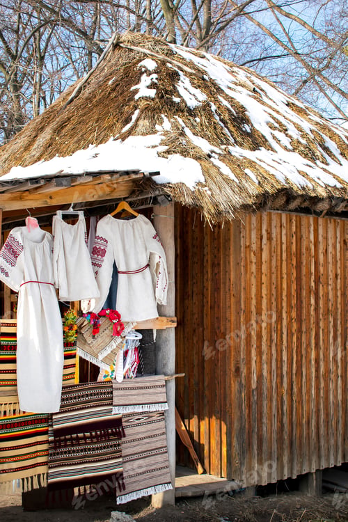 Preview: Different cotton linen womens dresses clothes embroidery souvenirs on straw old rural house wall
