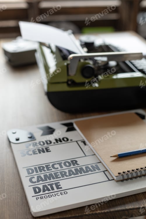 Preview: Clapper board and vintage typewriter at wooden desk table