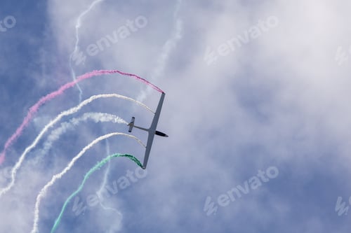 Preview: Airplane performing aerobatics with colored smoke trails.