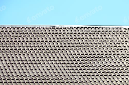 Preview: A fragment of a roof from a metal tile of dark red color. Quality Roofing