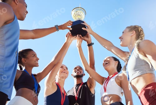 Preview: Low angle of a group of young fit diverse team of athletes celebrating their victory with a golden