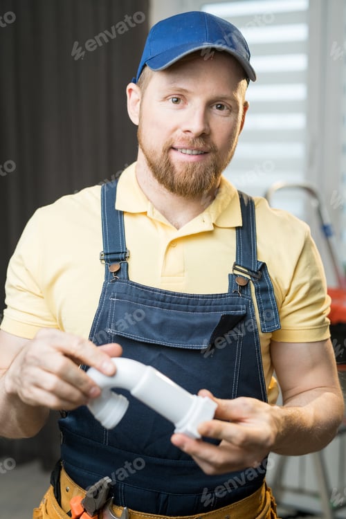 Preview: Handsome plumber holding pipe