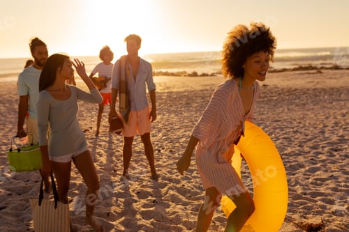 Preview: Mixed race friends group walking on beach