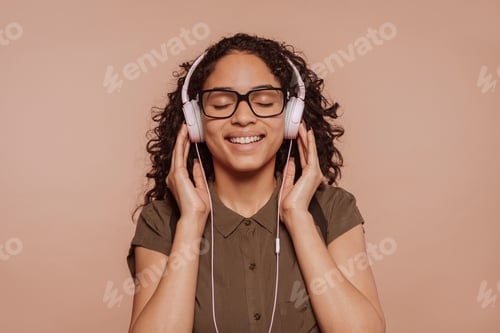 Preview: Young arabic woman listens music with headphones