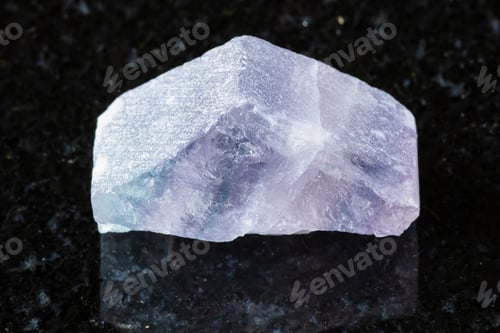 Preview: rough purple striped fluorite mineral on black