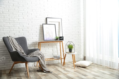 Preview: Stylish living room interior with comfortable armchair near brick wall. Space for text